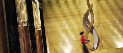 A person walking past a wall with a large, abstract design.