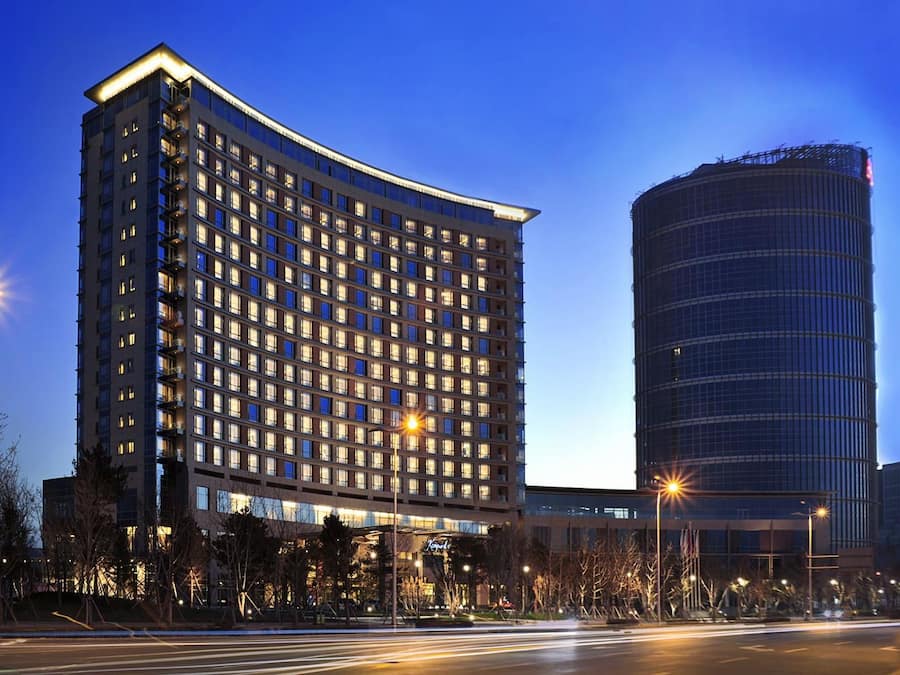 A multi-story hotel with a curved facade, large windows, and a modern design.