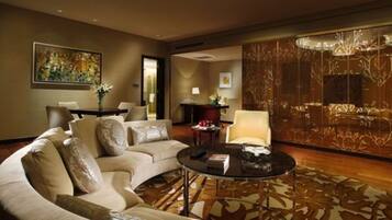 A spacious living room with a large sofa, a coffee table, and a decorative wall panel.