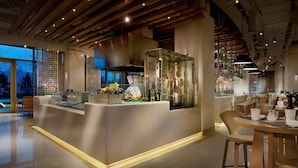 A modern restaurant with a central island, seating area, and a view of the outdoors. - Kempinski Hotel Yinchuan (Yinchuan)