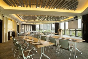 A conference room with a long table, chairs, and a projector screen. - Kempinski Hotel Yinchuan (Yinchuan)