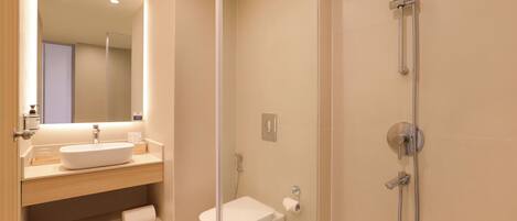 Un baño moderno con lavamanos, espejo y ducha.