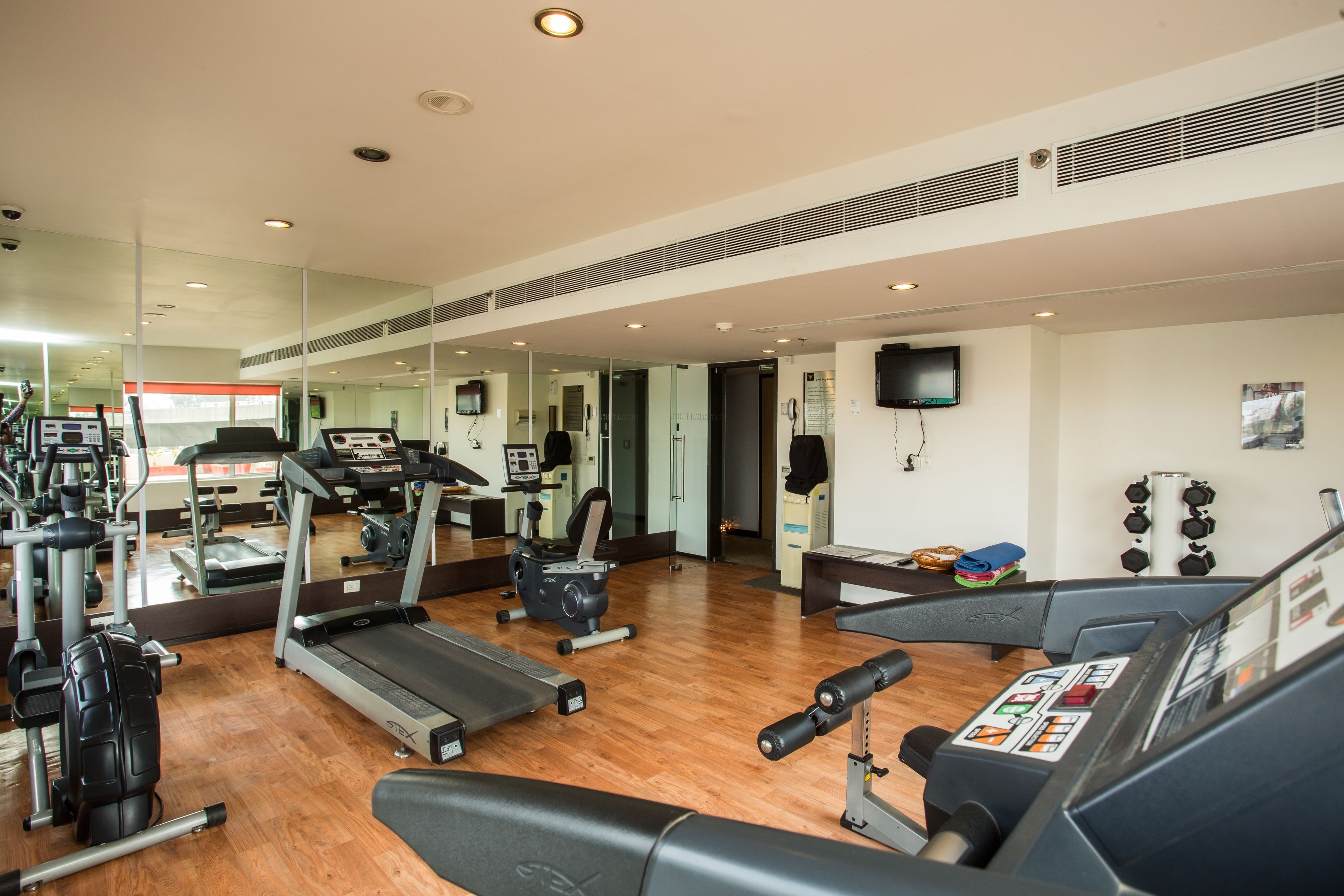 A gym with treadmills, elliptical machines, and weightlifting equipment.