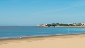 A beach with a lighthouse and buildings in the background. - Résidence Lagrange Vacances Les Maisons de Saint-Georges (Saint-Georges-de-Didonne)