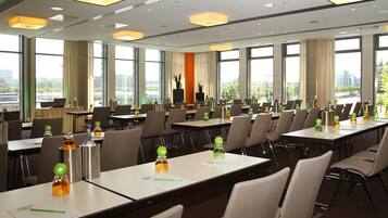 Un salón de conferencias con mesas, sillas y vistas a la ciudad.