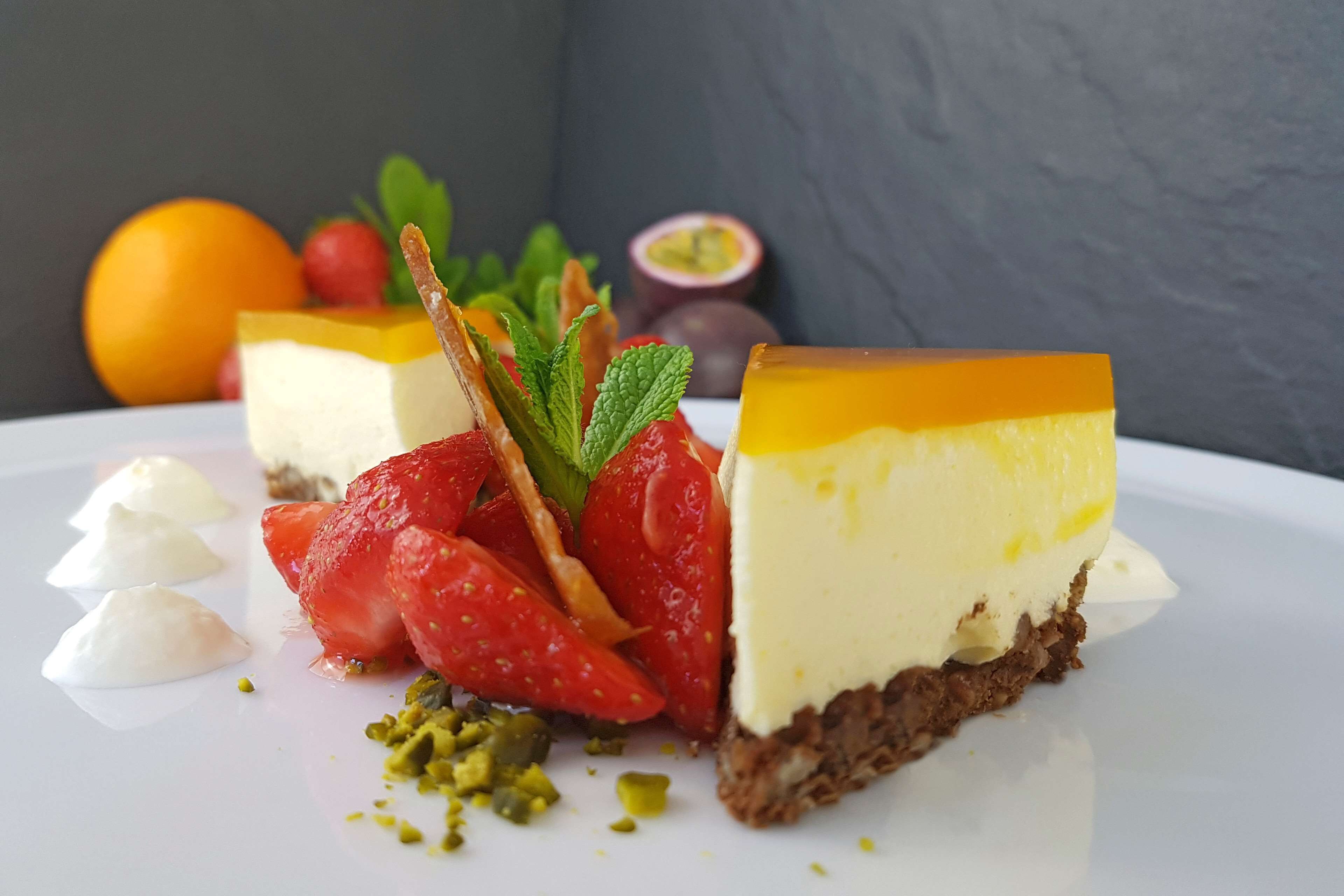 En desserttallerken med lagkage, jordbær, mynte og pistacienødder.