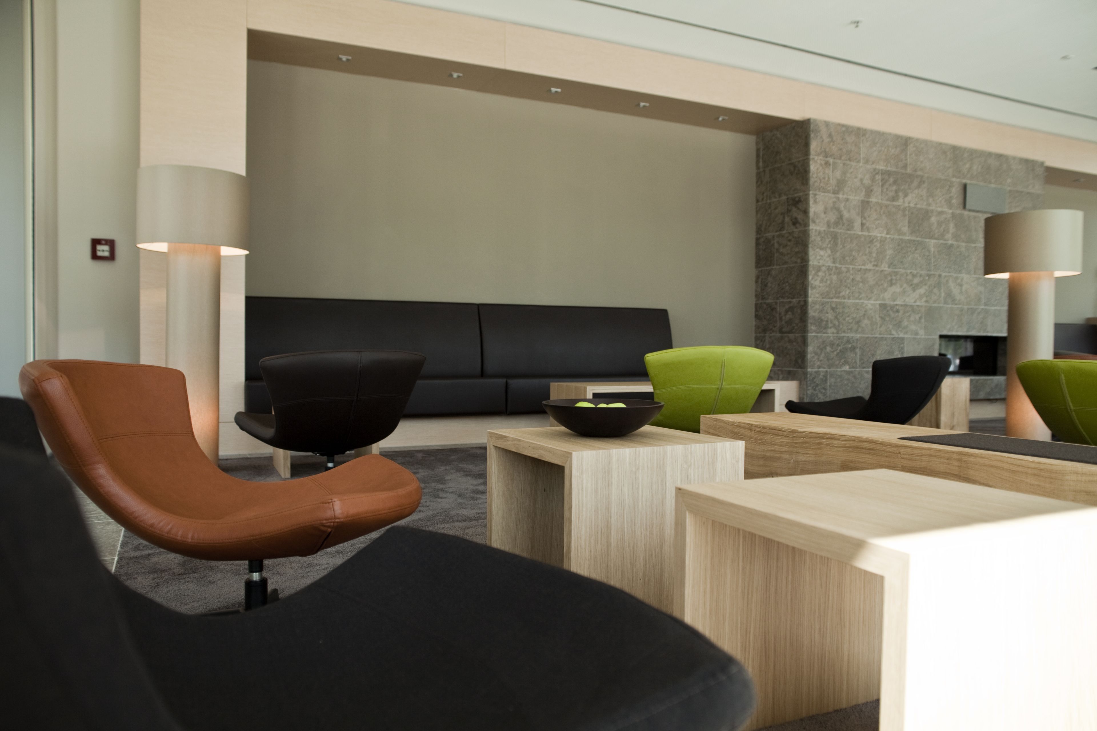 Un vestíbulo moderno con un sofá, sillas y una mesa de recepción.