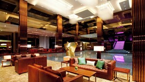 A spacious lobby with leather sofas, a coffee table, and a large abstract sculpture.