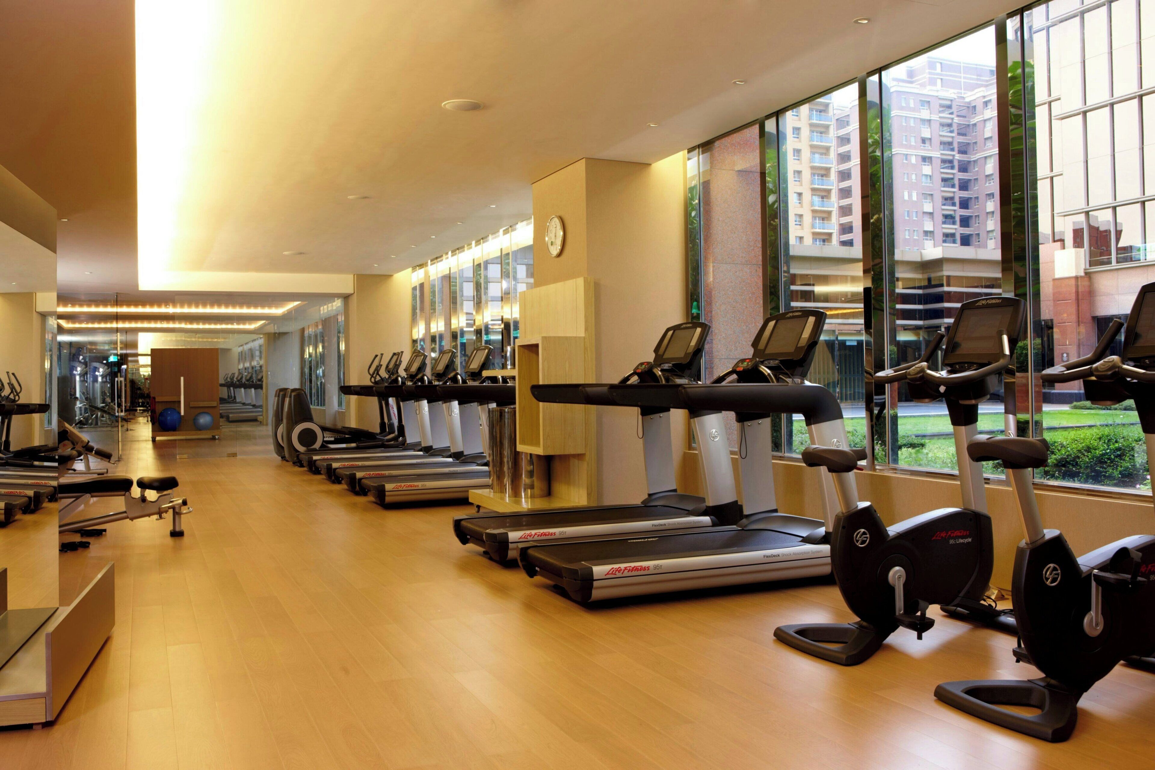 A gym with treadmills, elliptical machines, and rowing machines.