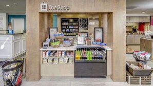 A small shop with a sign reading "The Shop" inside a mall. - Hilton Garden Inn Waldorf (Waldorf)