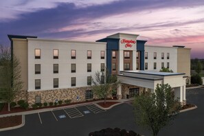 A Hampton Inn hotel with a modern design, a parking lot, and a clear sky. - Hampton Inn Yorkville (Yorkville)