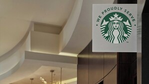 A Starbucks sign in a modern interior with a curved ceiling and pendant lighting. - Atlanta Airport Marriott Gateway (College Park)
