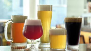 A variety of beverages on a table with a window in the background.