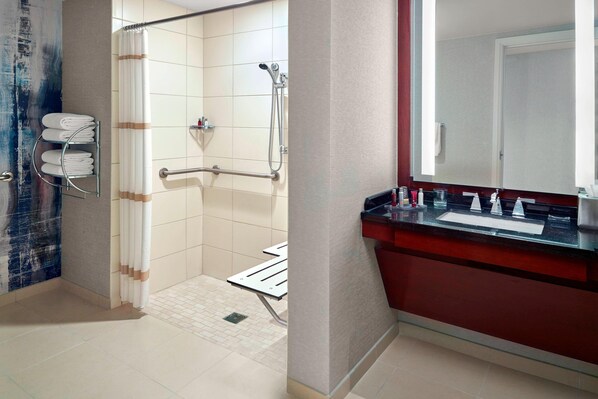 A modern bathroom with a shower, a toilet, and a sink.