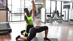 Una palestra con attrezzature per esercizi, tapis roulant e ampie vetrate.