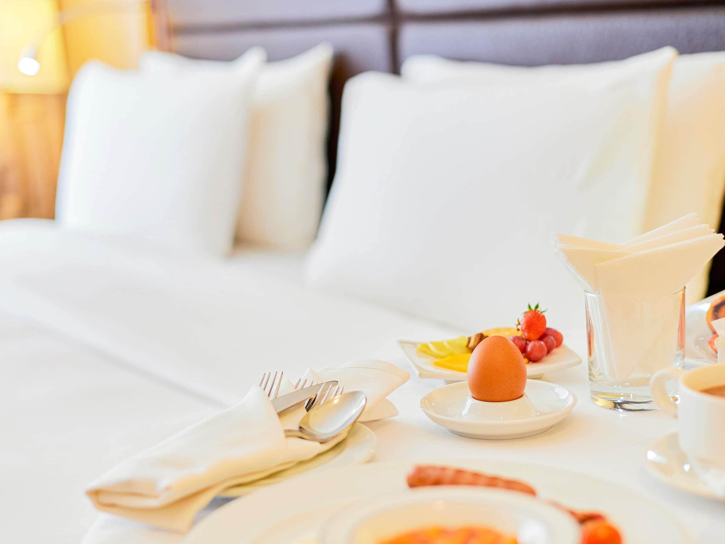A neatly arranged breakfast table with plates, cutlery, and a glass of water.