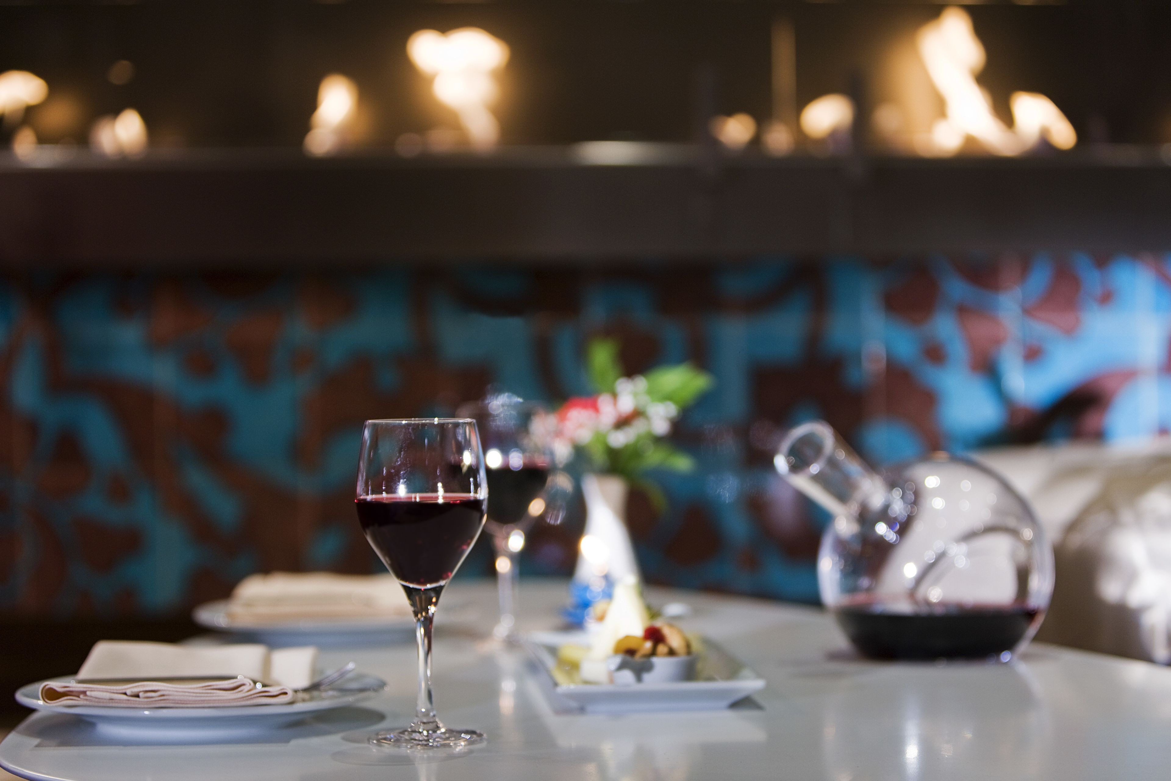 A dining table with a wine glass, plates, and a pitcher.