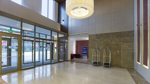 A spacious lobby with a glass entrance, a large chandelier, and a marble floor. - Hilton Garden Inn Kutahya (Kutahya)