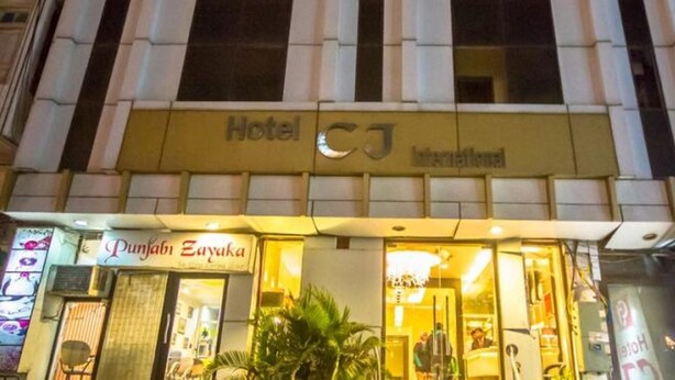 A hotel named 'Hotel CJ International' with a visible entrance and signage for 'Punjab Zayaka' adjacent to it. - Hotel CJ International (Amritsar)