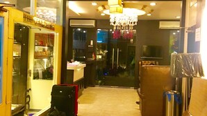 A hotel lobby with a seating area, a minibar, and a chandelier. - Hotel CJ International (Amritsar)