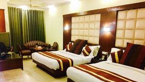 A hotel room with two beds, a desk, a chair, and a television. - Hotel CJ International (Amritsar)