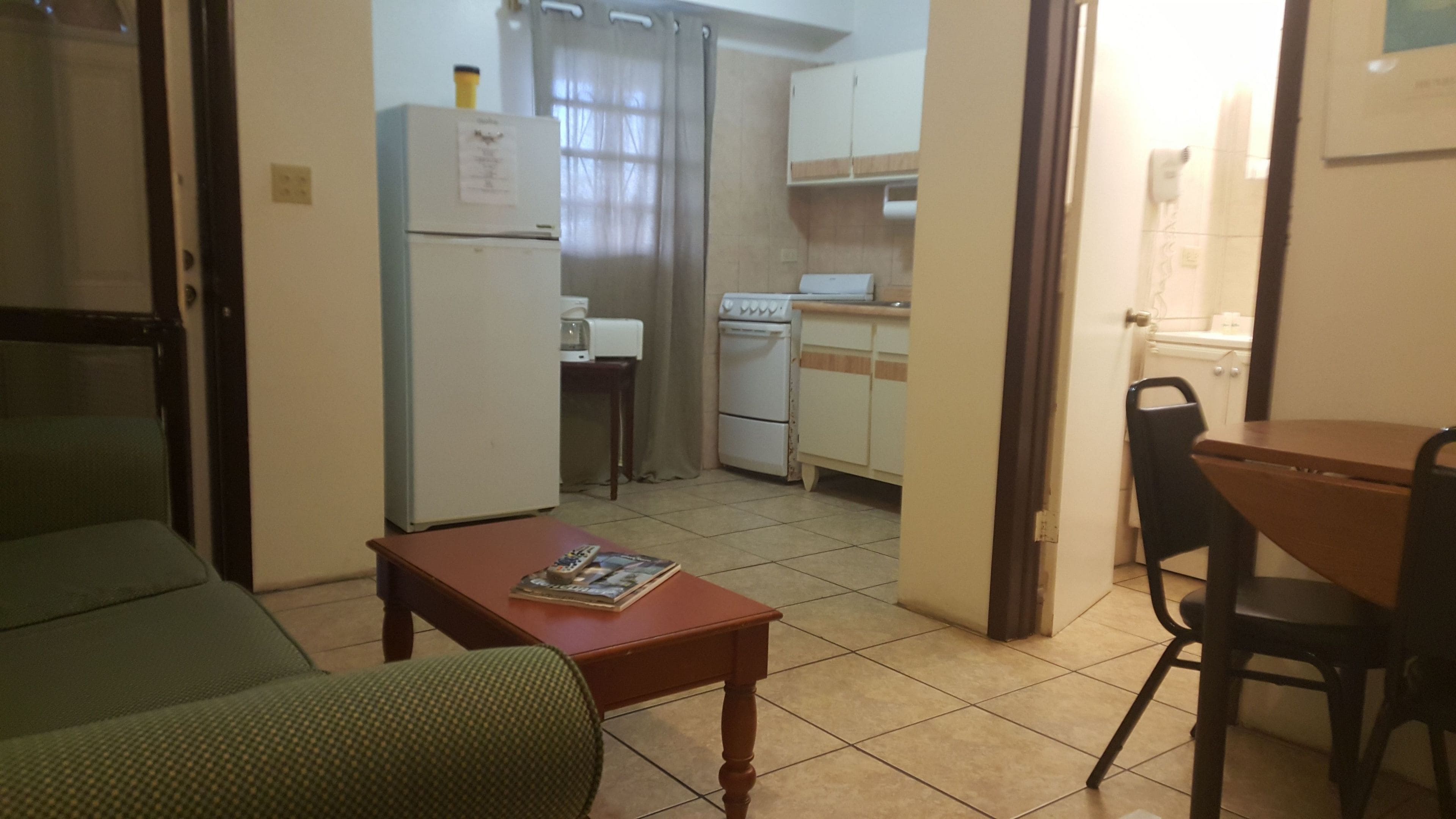 A compact living space with a kitchenette, a dining area, and a sofa.