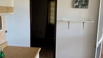 Una cocina con encimera de madera, un lavabo y una puerta que da a otra habitación.
