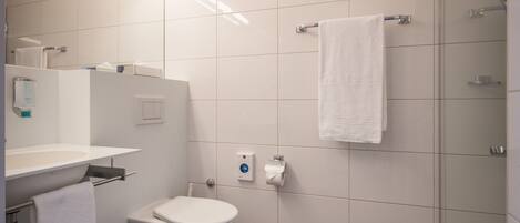 A modern bathroom with a toilet, sink, and shower area.