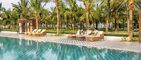 Alberca al aire libre, sombrillas en la alberca y camastros