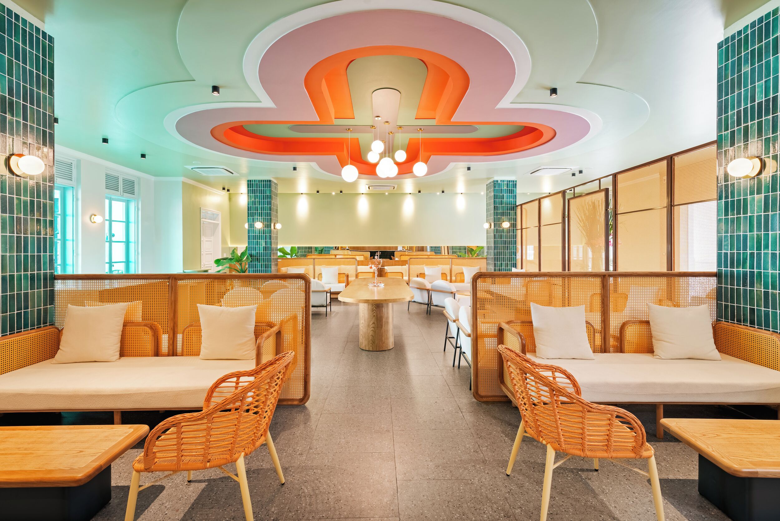 A spacious restaurant with high ceilings, modern lighting, and a central round table.