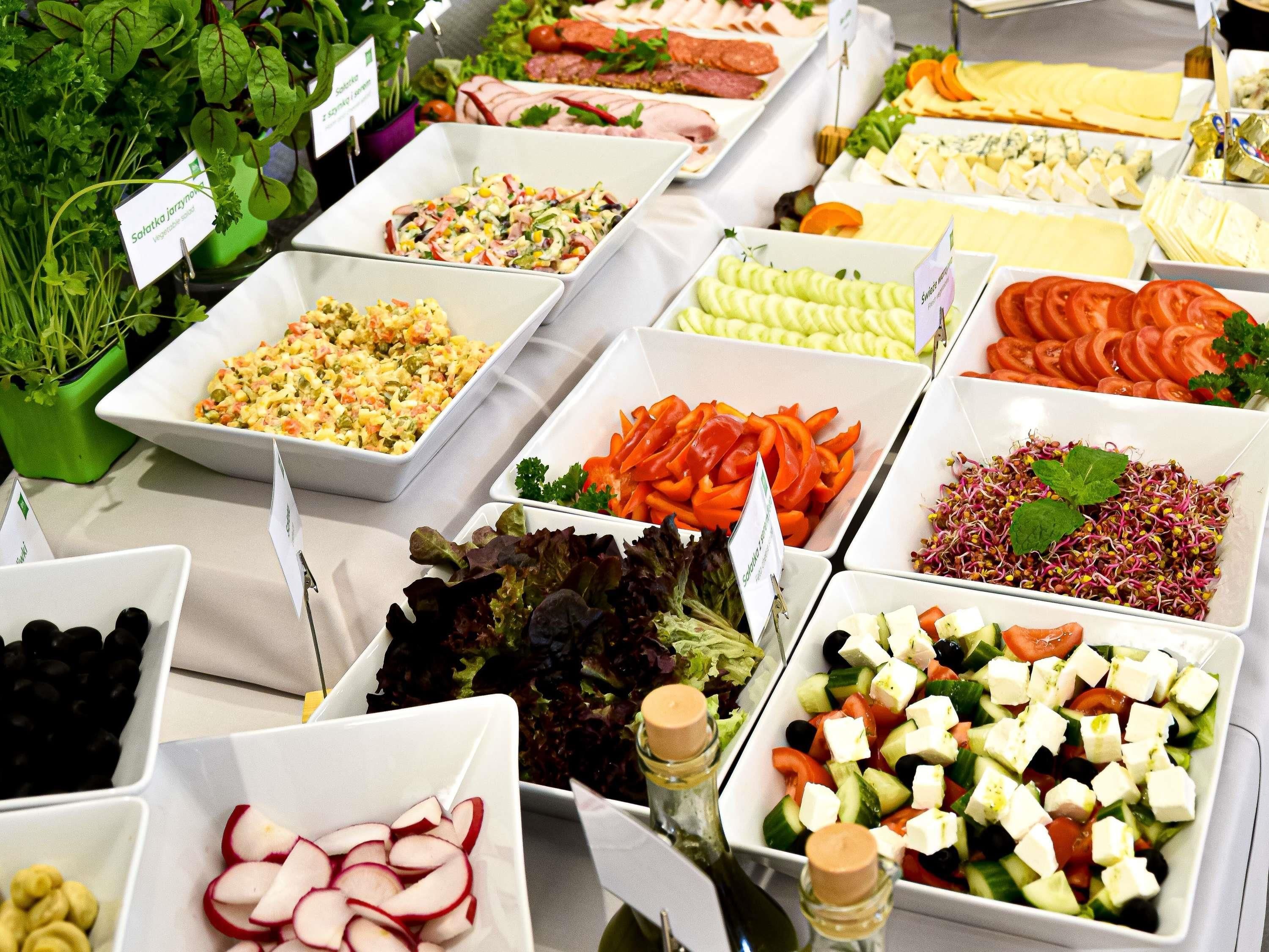 A buffet with various food options including salads, cheeses, and vegetables.