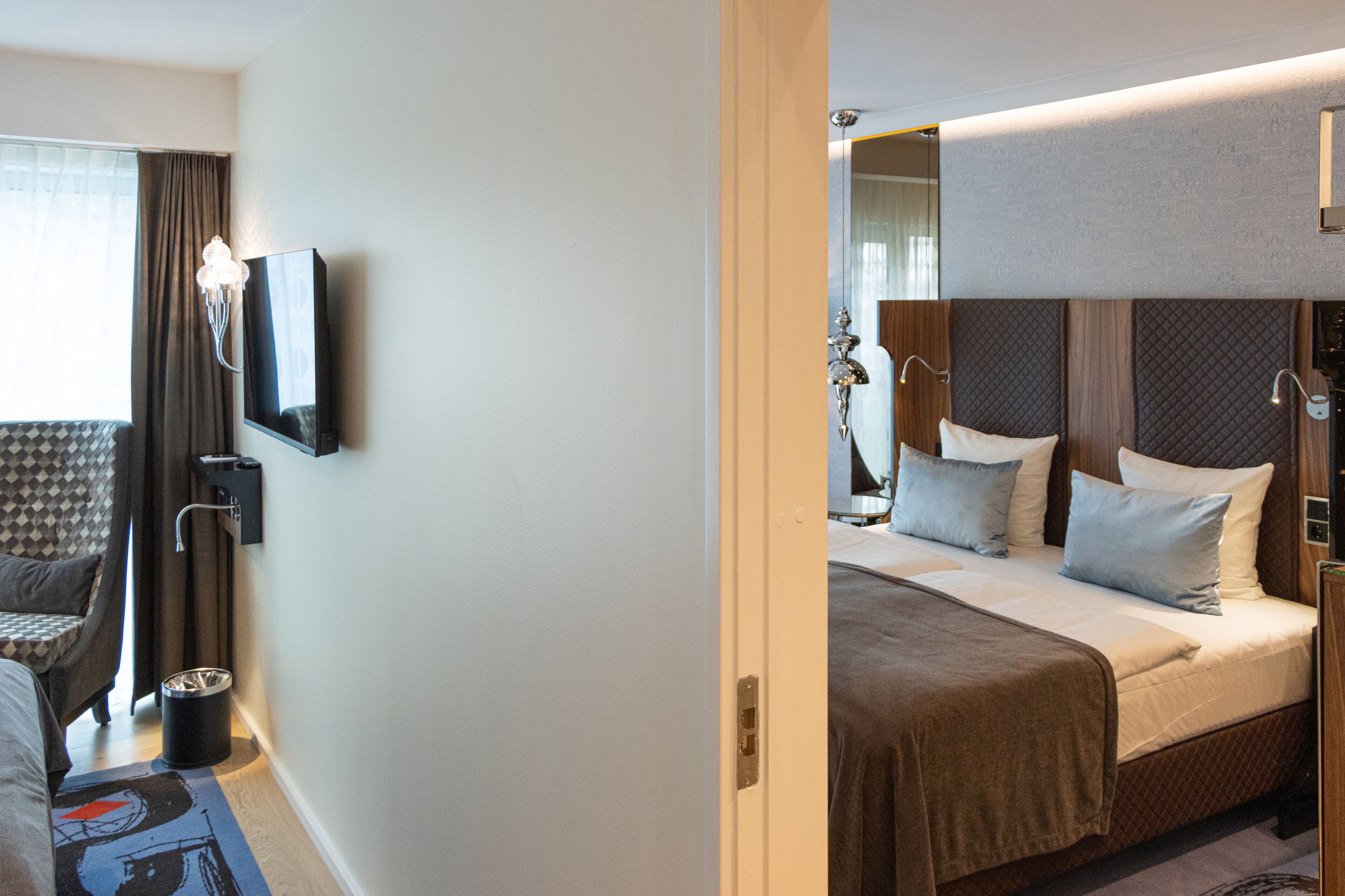 Une chambre d’hôtel avec un lit, une chaise, une télévision et une table de chevet.