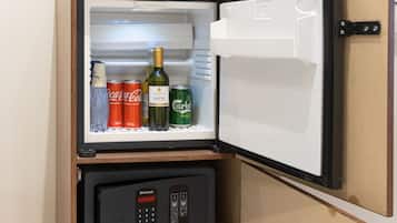 Un refrigerador con compartimento congelador, que contiene bebidas y un electrodoméstico pequeño.