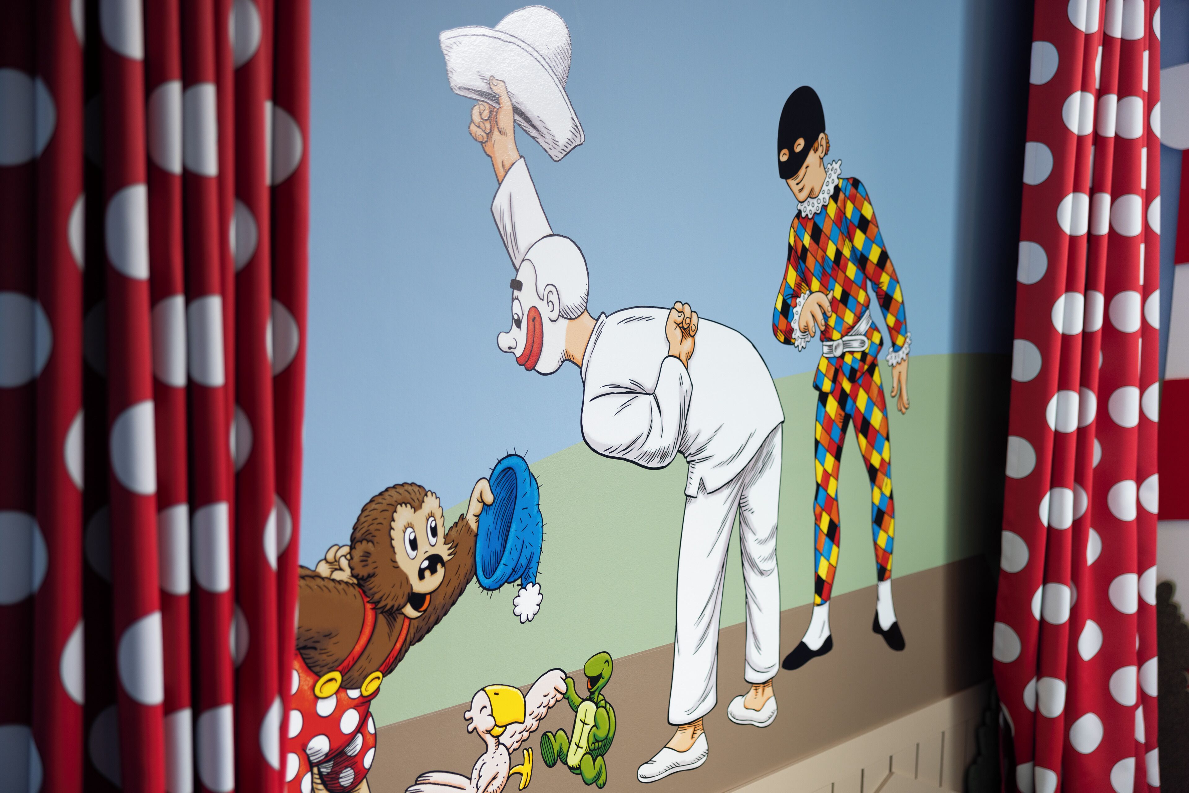 Un personaje de caricatura sosteniendo un sombrero, un payaso, un bufón y una tortuga.