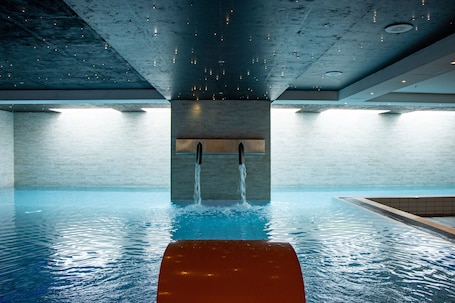 Una piscina techada, sillones reclinables de piscina