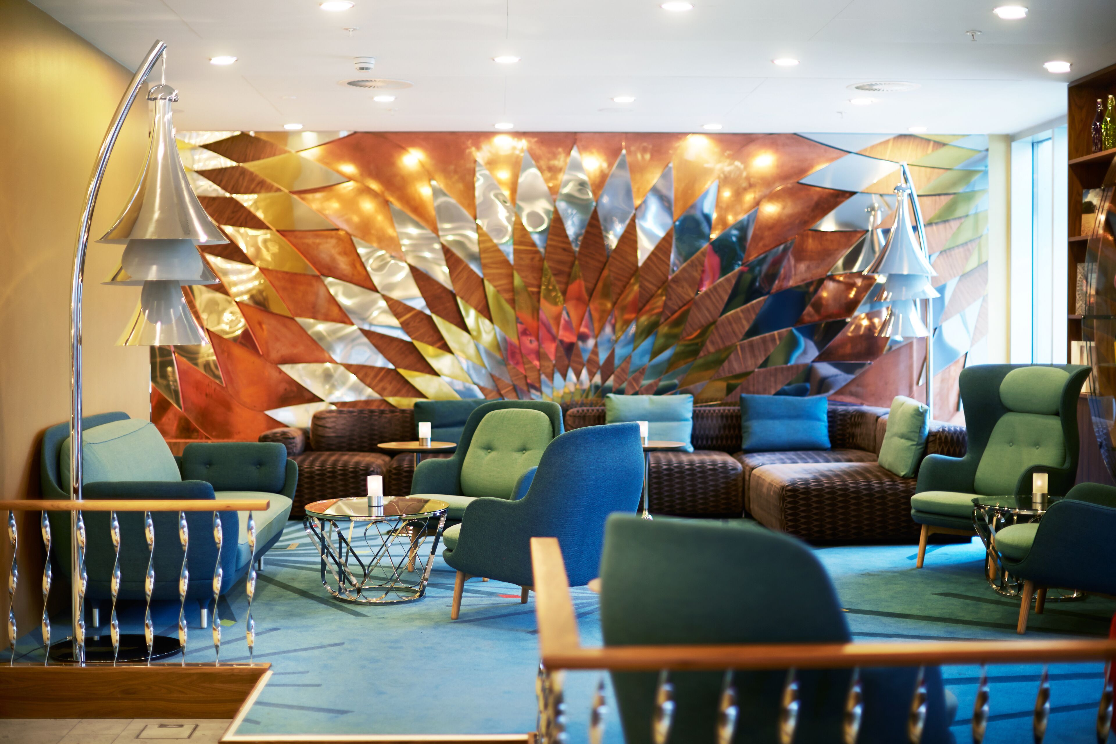 A modern lounge area with comfortable seating, a decorative wall, and ambient lighting.