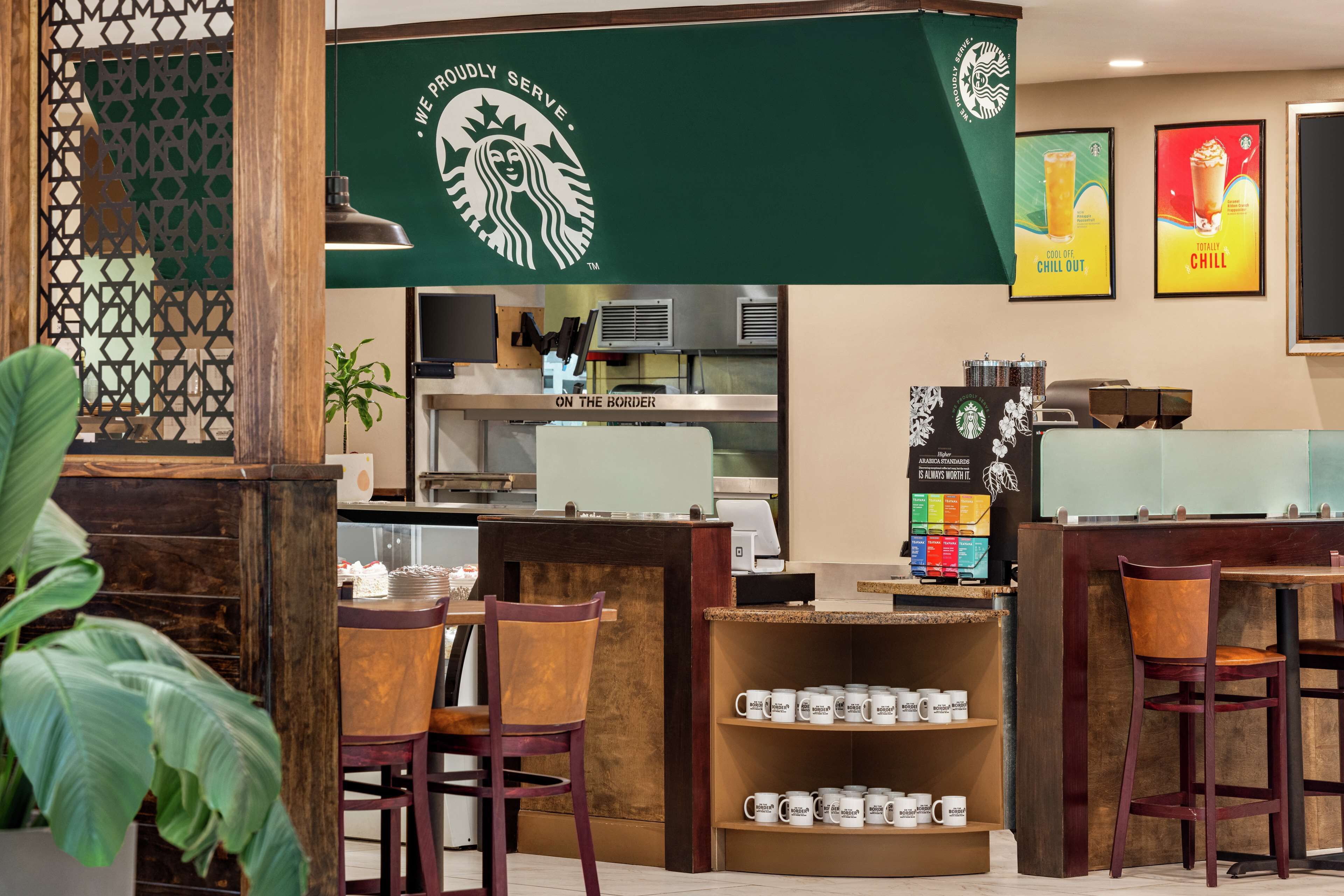 Ein Starbucks Café-Interieur mit Holztischen, einer Kaffeemaschine und einer Speisekarte.