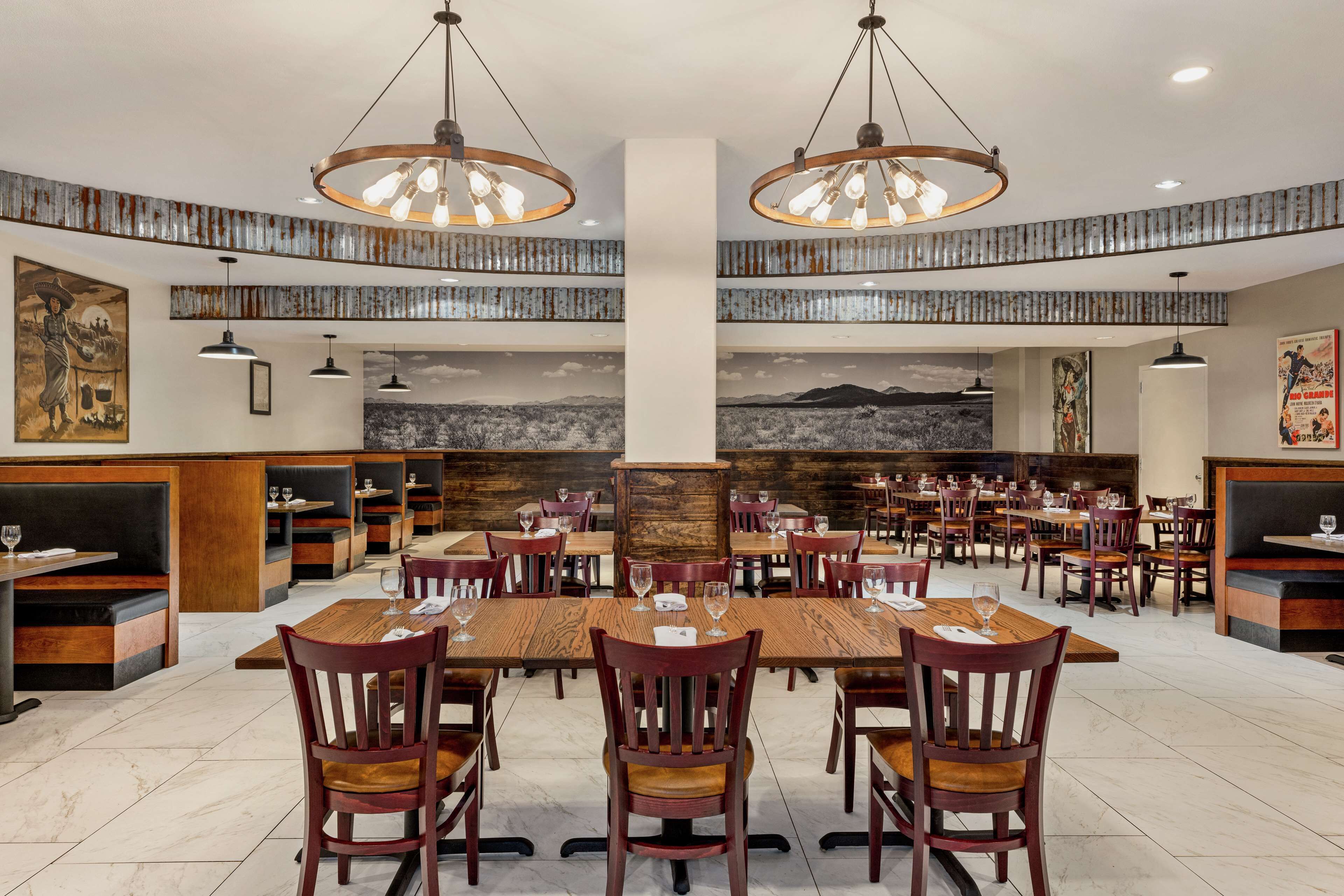 A restaurant with high tables and chairs, wooden accents, and artwork on the walls.