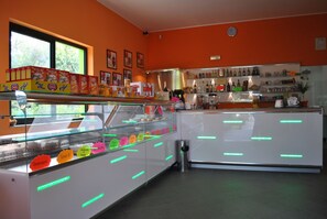Una panadería con un escaparate de vidrio lleno de pasteles coloridos y una gran variedad de productos horneados.