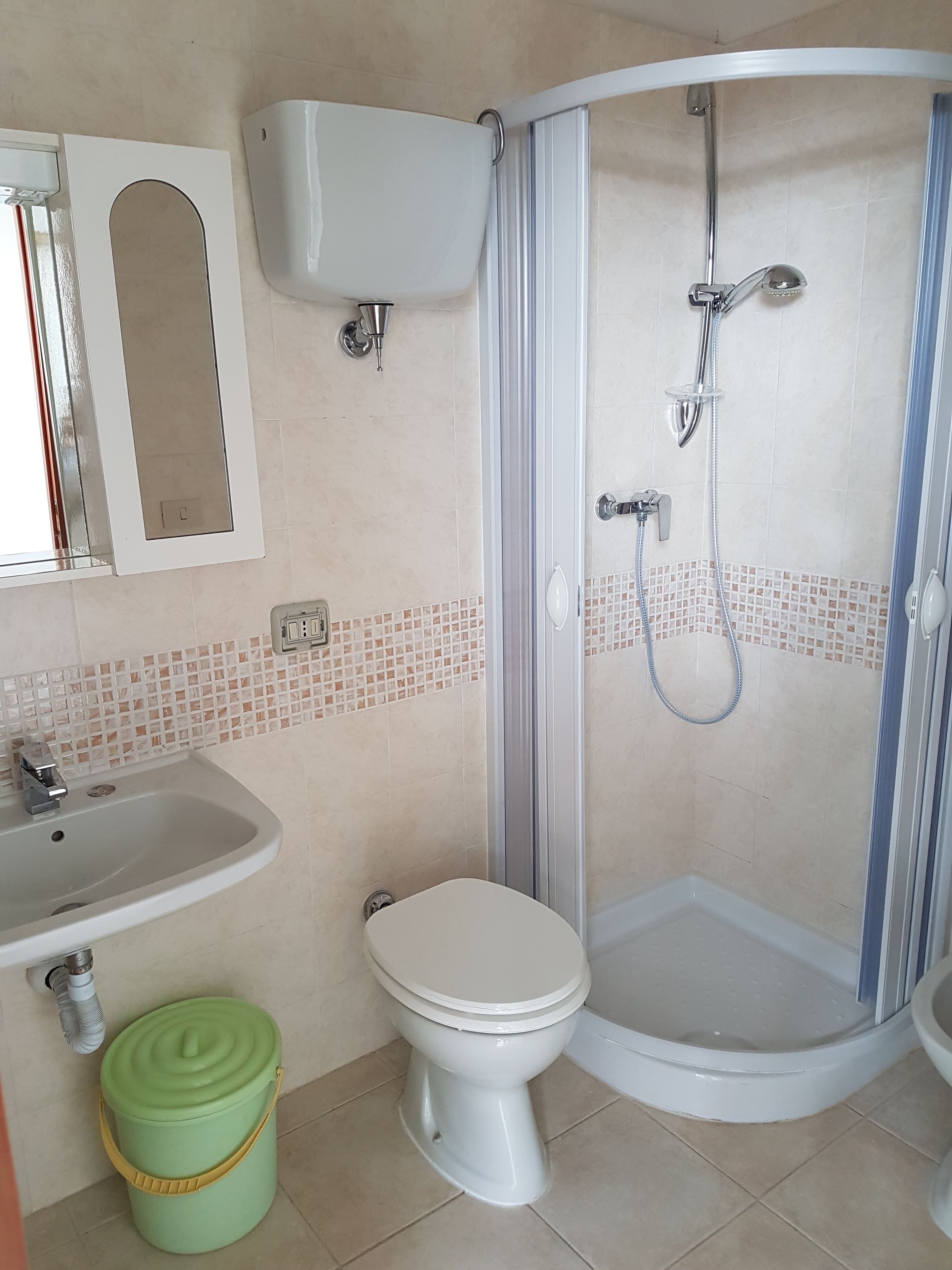 Een badkamer met toilet, wastafel en douche.