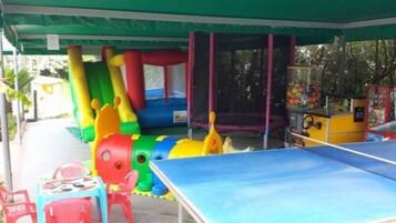Enjoy sports and leisure activities in this outdoor space with a ping pong table and play structures featuring slides and climbing elements.