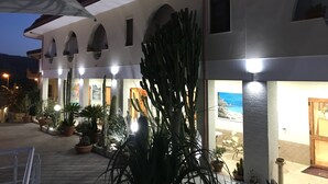 Un bâtiment doté de fenêtres en arc de cercle, d’une terrasse et de plantes en pot.
