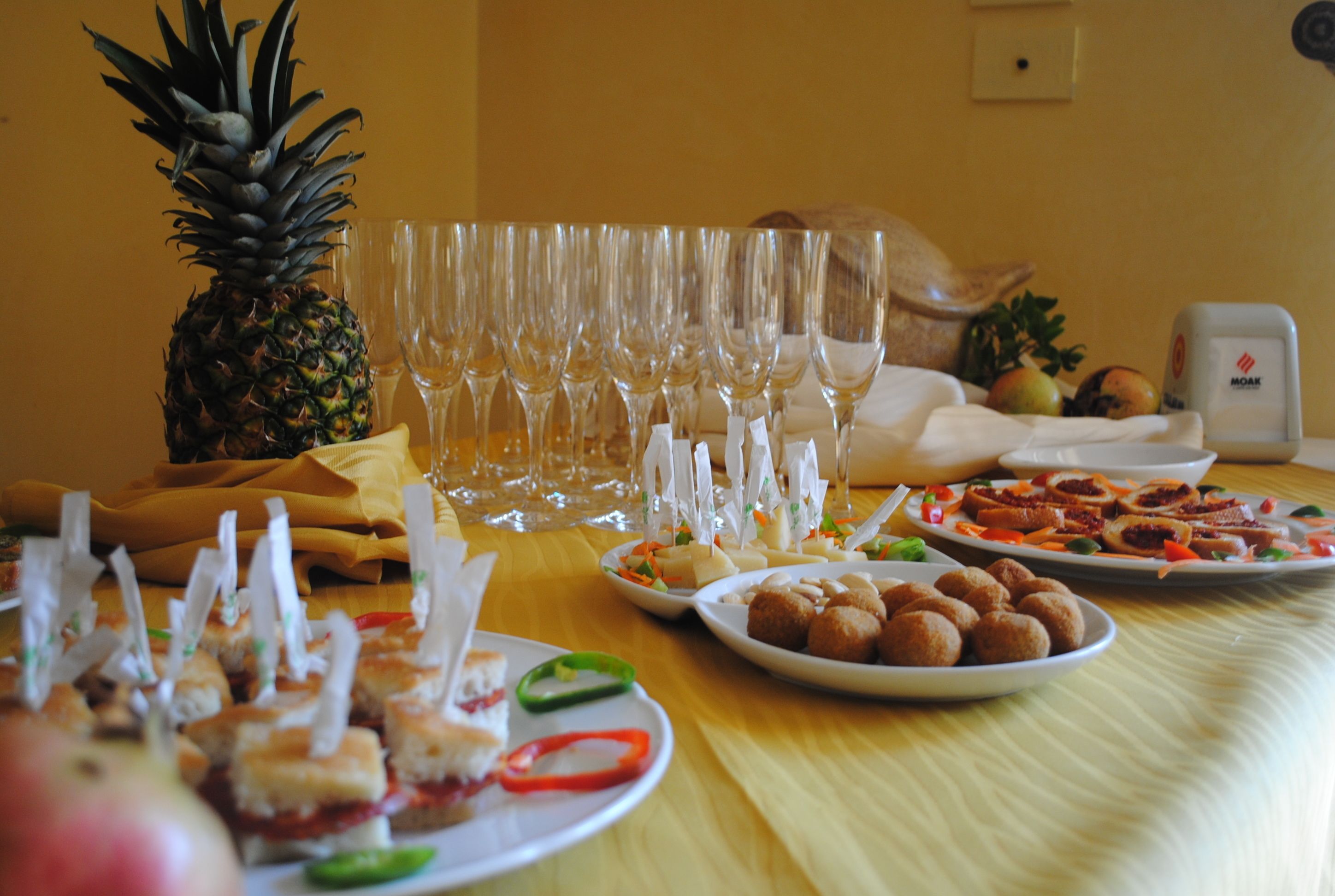 A table with various food items and empty wine glasses, suggesting a buffet or meal setup.