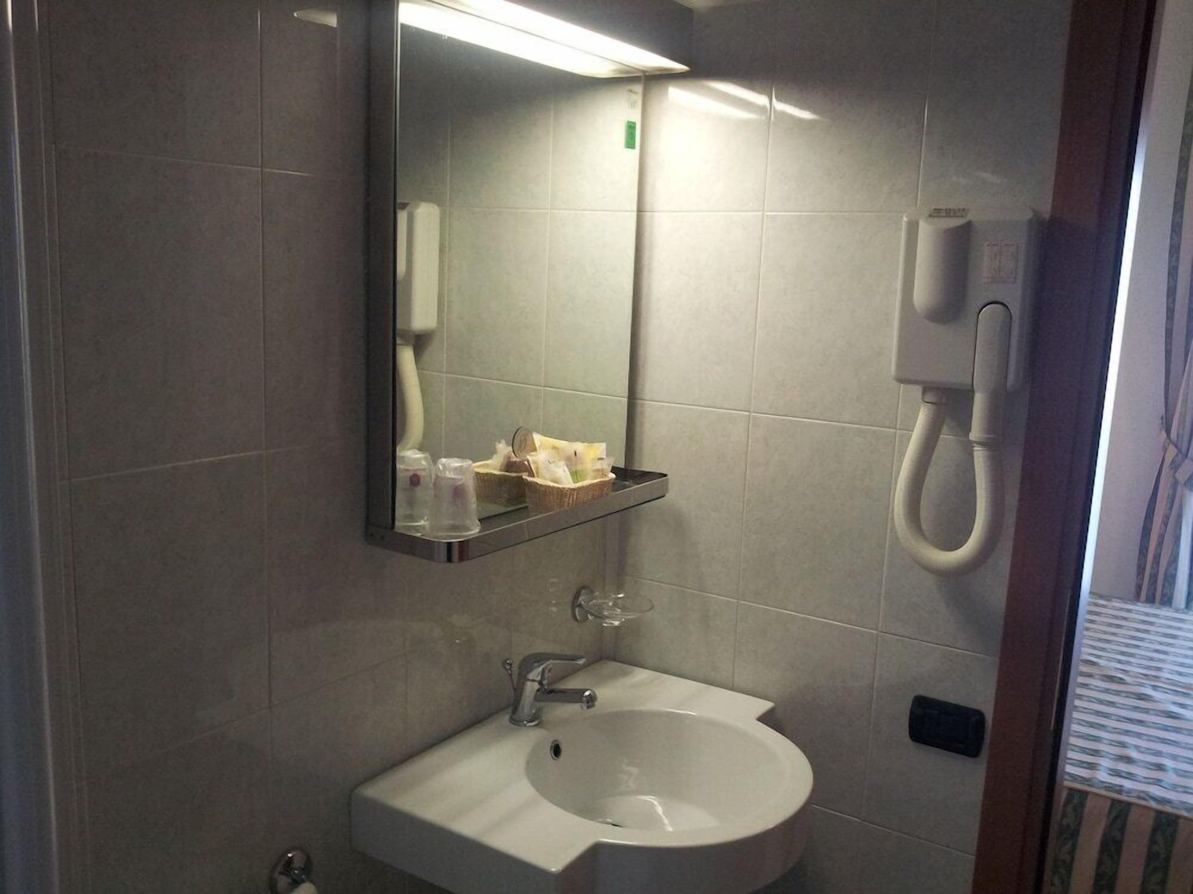 Une salle de bain équipée d’un lavabo, d’un miroir et d’un téléphone.
