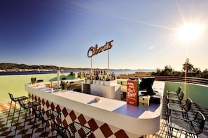 Een bar met uitzicht op zee, een bord met de tekst 'Cibano' en een menukaart.
