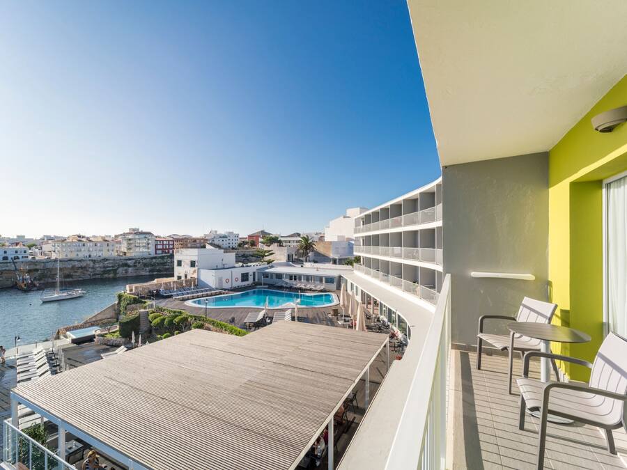 Un balcón con vistas a una piscina y al mar.