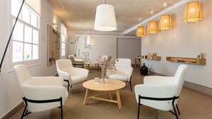 A modern interior with white leather chairs, a round wooden table, and pendant lights. - ARTIEM Carlos - Adults Only Hotel (Es Castell)