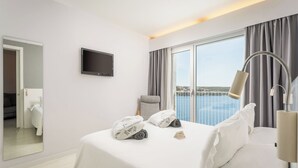 A hotel room with a bed, a TV, a balcony with a view, and a lamp. - ARTIEM Carlos - Adults Only Hotel (Es Castell)