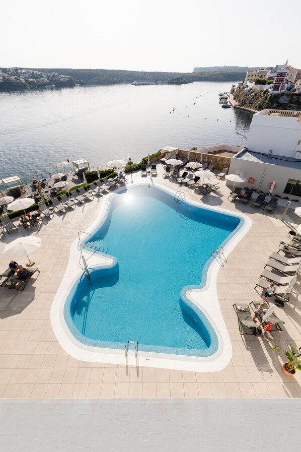 Una piscina al aire libre de temporada, sombrillas