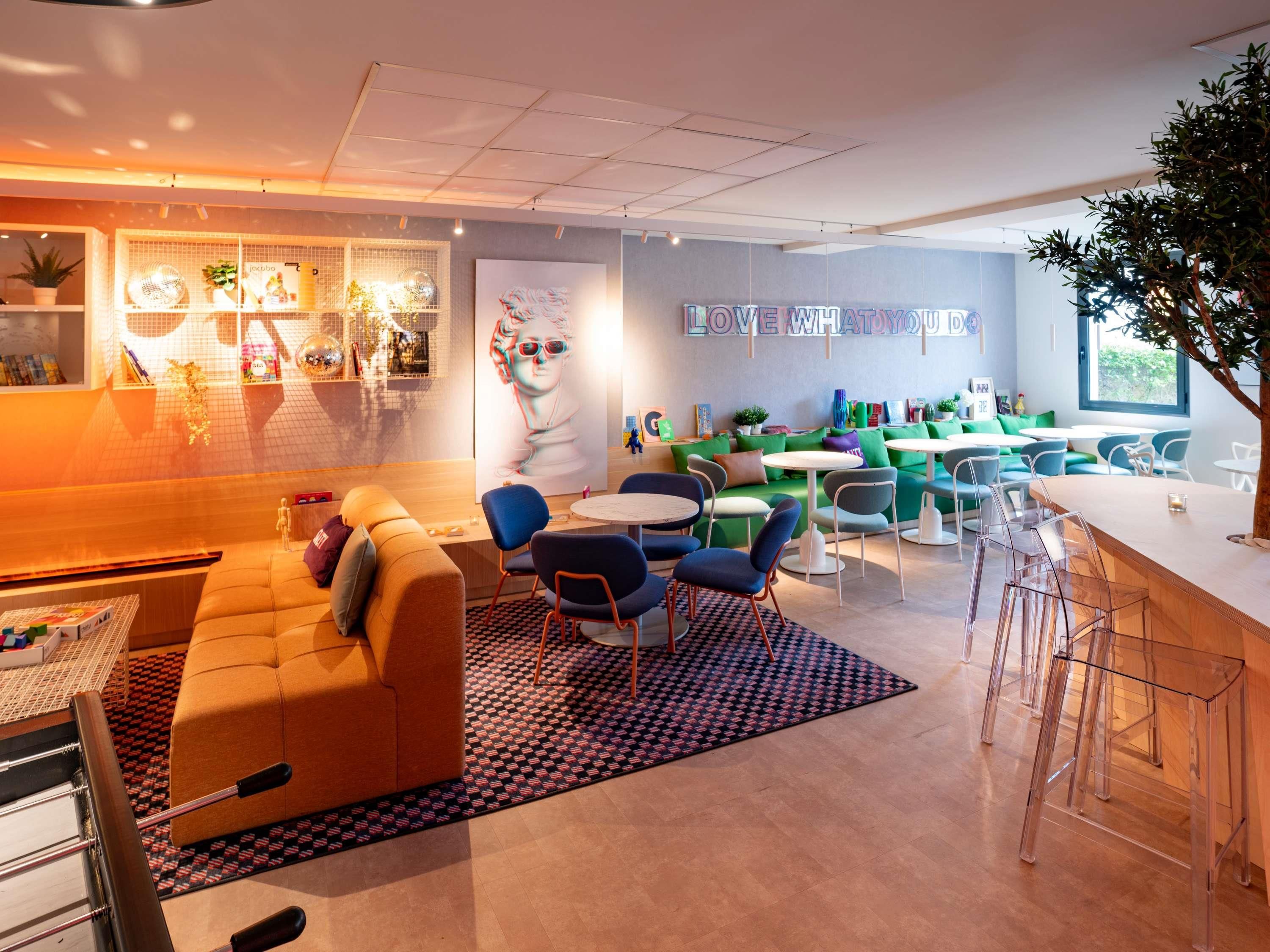 Un espace de détente moderne comprenant un canapé, des fauteuils et un coin bar.
